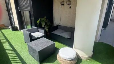 a patio with a couch and a chair and a stool at Apartment 300 m from the beach ,parking , breakfast in Valencia