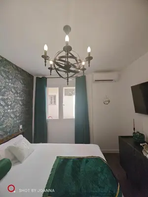 a bedroom with a large bed and a chandelier at Royal Lux in Sagunto