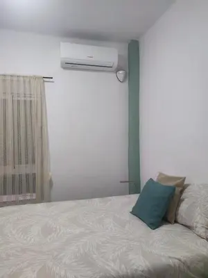 a bedroom with a bed with a blue pillow on it at La Casita de Cullera in Cullera