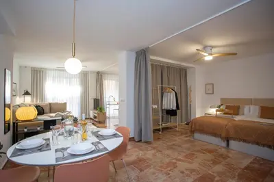a living room with a table and a bedroom at SingularStays Palau de la Musica Lofts in Valencia