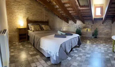 a bedroom with a large bed in a brick wall at Penthouse with two terraces near the sea in Valencia