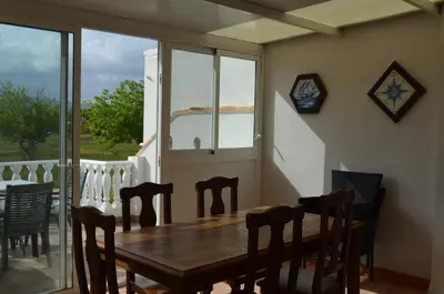 a dining room with a wooden table and chairs at Els Vents primera línea playa Puçol in Puzol