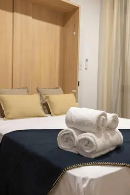 two beds with white towels on top of them at Travel Habitat Nou Mestalla Suites in Valencia