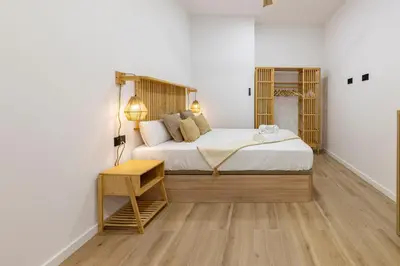 a bedroom with a large bed with a wooden headboard at Travel Habitat Nou Mestalla Suites in Valencia