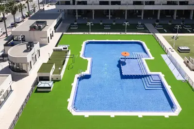 an overhead view of a large swimming pool with a orange ball on it at Apartamento con Vistas al mar, Piscina y Pista de Paddle in Valencia