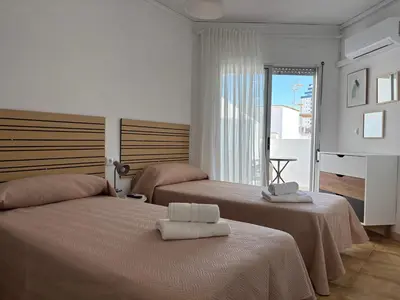 a hotel room with two beds and a window at VMC Rooms in Tavernes de Valldigna