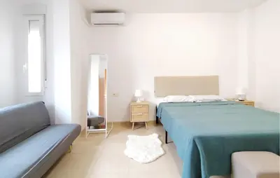 a white bedroom with two beds and a couch at Pet Friendly Home In Puerto De Sagunto in Puerto de Sagunto
