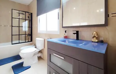 a bathroom with a toilet and a blue sink at Pet Friendly Home In Puerto De Sagunto in Puerto de Sagunto