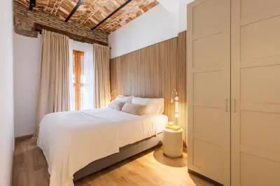 a bedroom with a white bed and a brick wall at Luxury apartament, close to Cabañal Beach, Late Checkout in Valencia