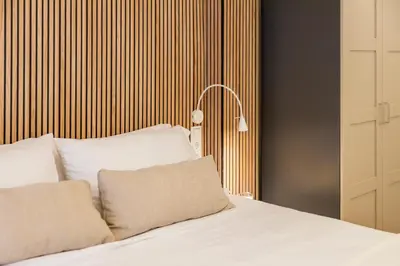 a bedroom with a bed with white sheets and a lamp at Luxury apartament, close to Cabañal Beach, Late Checkout in Valencia