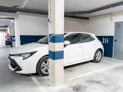 a white car parked in a parking garage at Winahost Apartment Neo Residencial Mediterráneo in Barrio-Mar