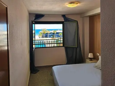 a bedroom with a large bed and a wooden cabinet at Apartamento Brisa Patacona in Valencia