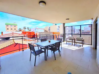 a dining room with a table and chairs on a balcony at Apartamento con Terraza junto al Mar en Moncofa in Moncófar