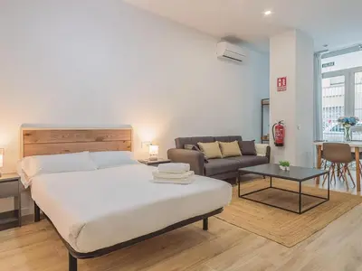 a bedroom with a bed and a couch and a table at Winahost Apartamento Benimaclet 1 in Valencia