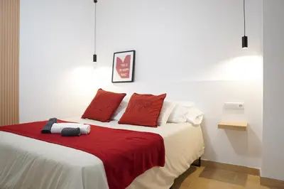 a bedroom with a bed with red pillows at Céntrico & Lujoso in Valencia