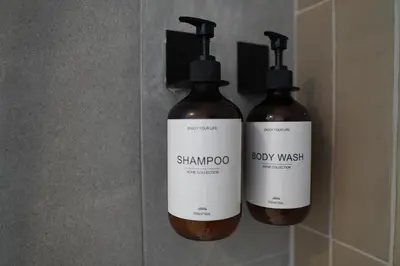 two bottles of shampoo and soap on a wall at Céntrico & Lujoso in Valencia