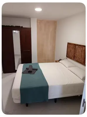 a bedroom with a large bed with a hat on it at Sueños en la playa in Valencia