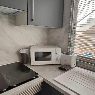 a kitchen counter with a microwave and a sink at Piso A playa 19 in Puerto de Sagunto