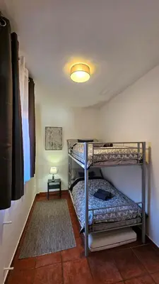 a bedroom with two bunk beds and a lamp at Casa Rural Torás Piscina, BBQ, Chimenea y WiFi 600Mb in Torás