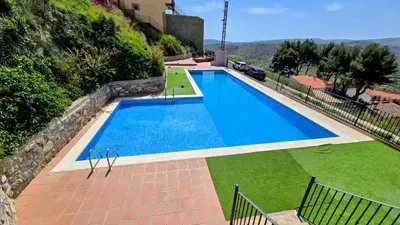 a large swimming pool with green grass and a building at Casa Rural Torás Piscina, BBQ, Chimenea y WiFi 600Mb in Torás