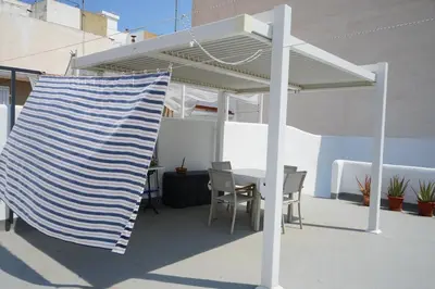 a patio with a table and chairs under a canopy at Lorea Puerto in Puerto de Sagunto