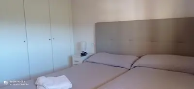 a small bedroom with two beds and a mirror at Apartamento Cullera Playa in Cullera