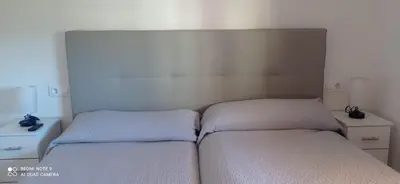 a bedroom with two twin beds and a headboard at Apartamento Cullera Playa in Cullera