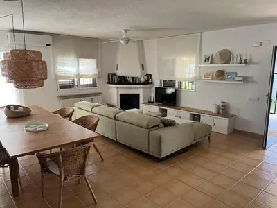 a dining table and chairs in a living room at Villa 20min Valencia - Playas in San Antonio de Banageber