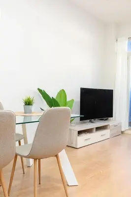 a living room with a table with chairs and a television at Beachside Apartment Valencia Ideal for Digital Nomads in Valencia
