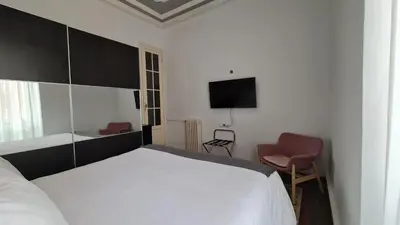 a bedroom with a bed and a tv and a chair at The Plaza Residence in Valencia