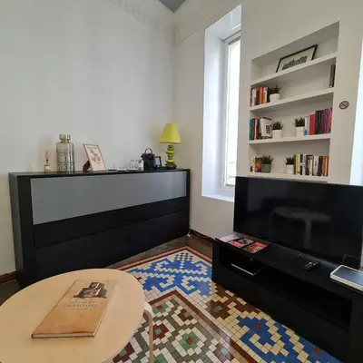 a living room with a tv and a table at The Plaza Residence in Valencia
