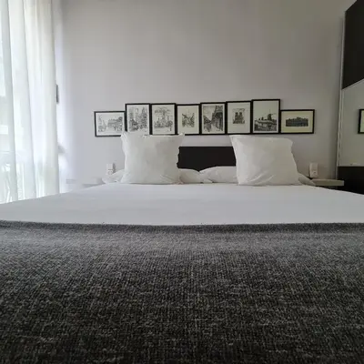 a bedroom with a large white bed with pictures on the wall at The Plaza Residence in Valencia