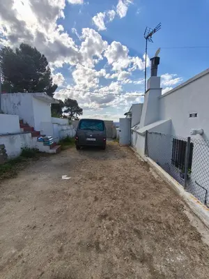 a car parked in a dirt lot next to a building at Casa en la montaña con jacuzzi exterior y piscina in Alcántara de Júcar