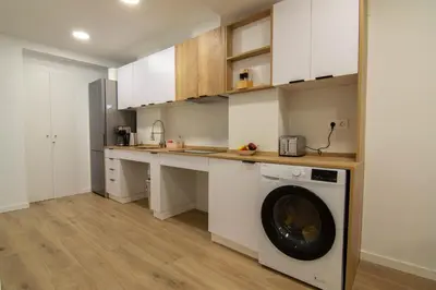 a kitchen with white cabinets and a washing machine at Casa Pedro Cabanes in Valencia