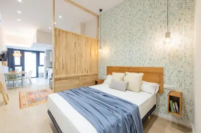 a bedroom with a bed with a blue and white blanket at Marina Arts Lofts in Valencia