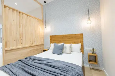 a bedroom with a bed with a wooden headboard at Marina Arts Lofts in Valencia