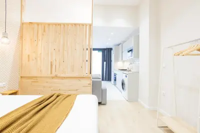 a bedroom with a white bed and a kitchen at Marina Arts Lofts in Valencia