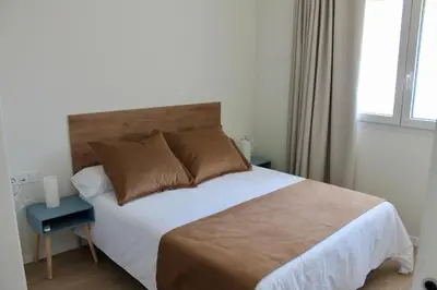 a bedroom with a large bed and a window at Arenisca Zarco in Valencia
