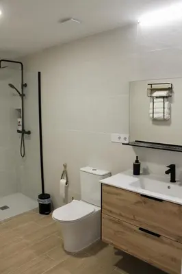 a white bathroom with a toilet and a sink at Arenisca Zarco in Valencia