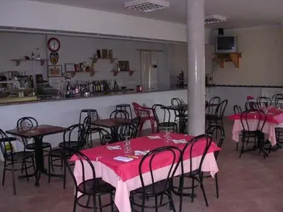 a swimming pool with chairs and umbrellas next to a building at Cabañas y Bungalows La Falaguera in Bárig