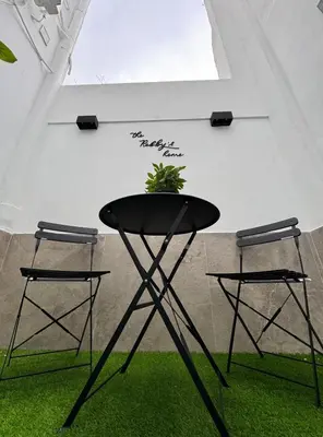 a black table with two chairs and a plant on it at The Robby's home in Valencia