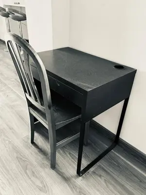 a black desk with a chair next to a wall at Atico con vistas al atardecer admitanse mascotas in El Puig