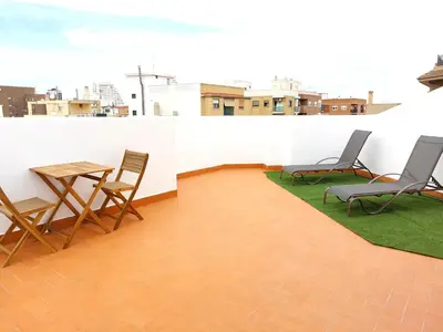 a patio with chairs and a table on a roof at ATTIC ROOMs VALENCIA in Valencia