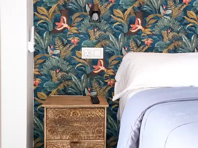 a bedroom with a bed and a floral wallpaper at ATTIC ROOMs VALENCIA in Valencia