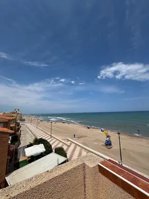 a view of a beach with people and the ocean at El Encanto del Perelló in Sueca