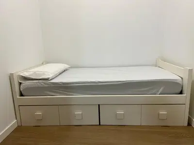 a bed in a room with a white wall at Turia Loft Valencia in Valencia
