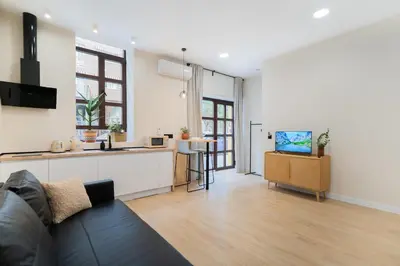 a living room with a couch and a kitchen at Apartments LEON GABRIEL MIRÓ in Valencia