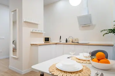 a white kitchen with a table with oranges on it at Apartments LEON PARE RICO in Valencia