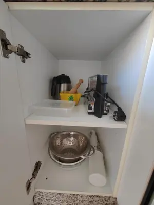 a kitchen shelf with a bowl and other kitchen utensils at Au bord de la plage in Puerto de Sagunto