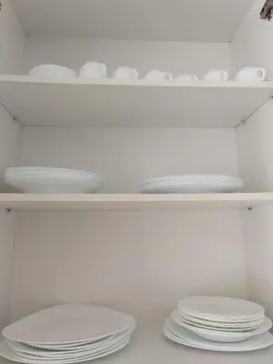 a white shelf with plates and dishes on it at Au bord de la plage in Puerto de Sagunto